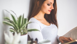 Young Woman Relaxing at Home and Reading a Book